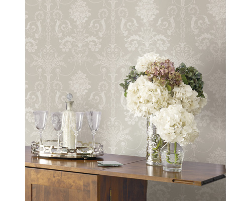 Tapete mit floralem Muster über einem Holzschrank mit Blumenschmuck und Getränkeausstattung