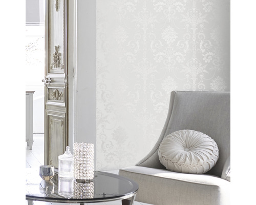 Helles Interieur mit gemusterter Tapete, Sessel und Tisch