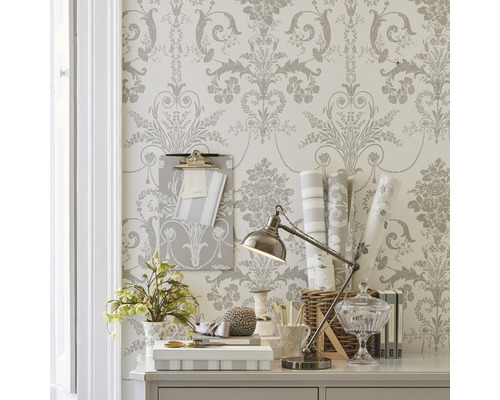 Dekorativer Schreibtisch mit floraler Tapete, Schreibtischlampe und Büroartikeln