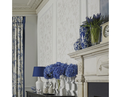 Wohnzimmer mit floraler Tapete, Vorhängen mit Blumenmuster und dekorativen Accessoires