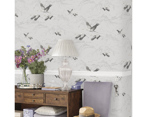 Wohnraumgestaltung mit Tapete mit Kranichmuster, Holzkommode, Lampe und Dekoration