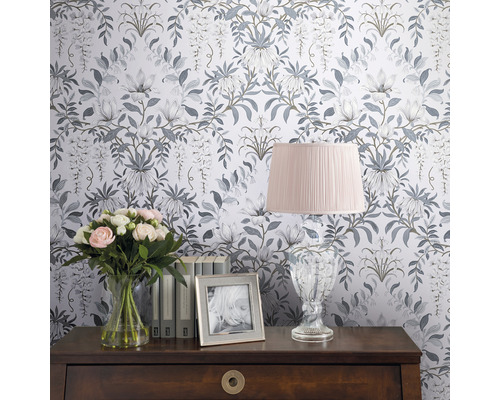 Dekoratives Zimmer mit Blumentapete, Tischleuchte, Blumenstrauß und Bilderrahmen