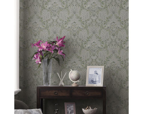 Zimmer mit floraler Tapete, dunklem Holzschrank, Blumen und Dekorationsartikeln