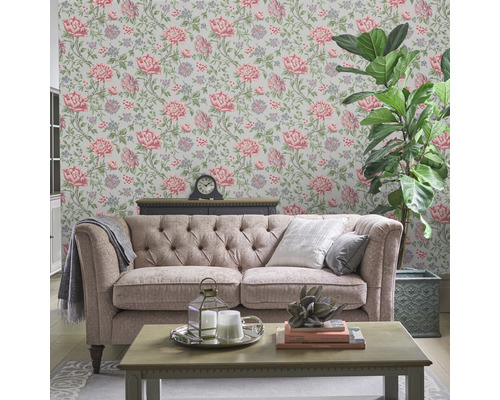 Wohnzimmer mit floral gemusterter Tapete, Sofa und Zimmerpflanze