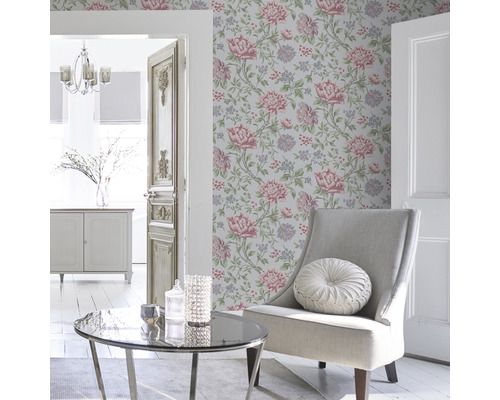 Wohnzimmer mit blumiger Tapete, Sessel und Couchtisch