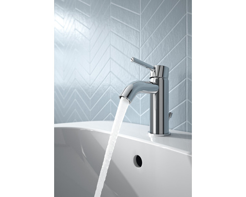 Wasserhahn aus Chrom mit Wasserlauf auf einem Waschbecken