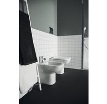 Badezimmer mit Bidet, Toilette, Handtuchhalter und Fliesen