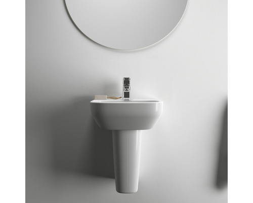 Waschtisch mit Armatur und rundem Spiegel für das Badezimmer