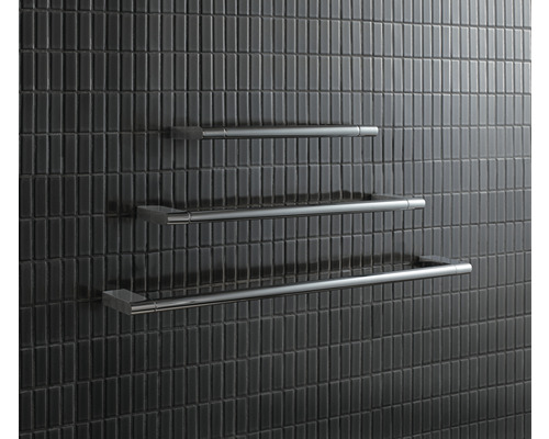 Drei Handtuchhalter aus Metall an einer gefliesten Wand