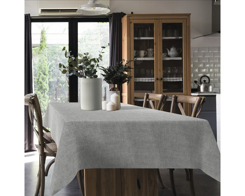 Esstisch mit grauer Tischdecke in heller Küche.