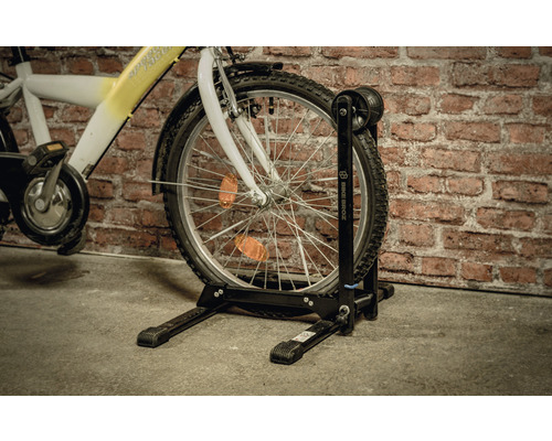 Fahrrad mit Fahrradhalterung vor einer Ziegelwand