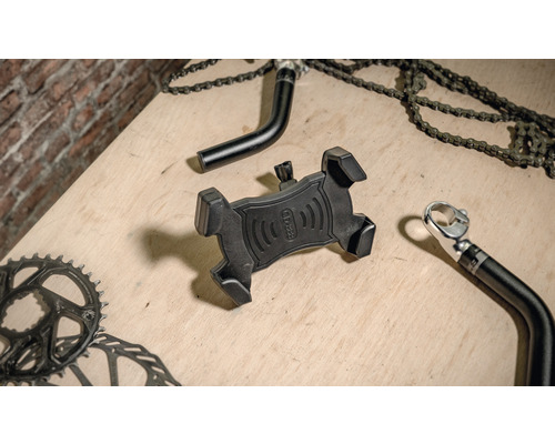 Schwarze Smartphone-Halterung für Fahrräder auf einer Holzoberfläche mit Fahrradteilen