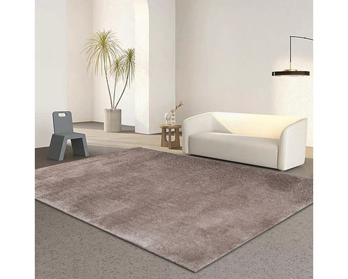 Wohnzimmer mit einem braunen Teppich, einem weißen Sofa und einem grauen Stuhl.