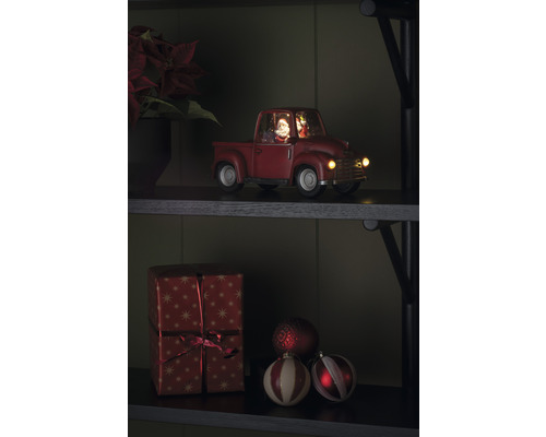 Dekorativer Weihnachtstruck mit Weihnachtsmann und Geschenk auf einem Regal