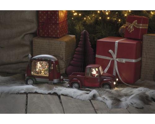 Dekorative Szene mit einem roten Spielzeug-Truck mit Anhänger, Weihnachtsbäumen und Geschenken