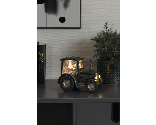 Dekorativer Schneeball Traktor mit Weihnachtsmann auf einem Schrank