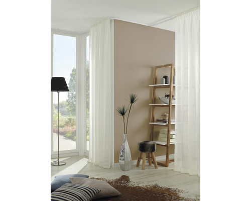 Helles Wohnzimmer mit weißen Vorhängen, Holzregal und dekorativen Elementen.