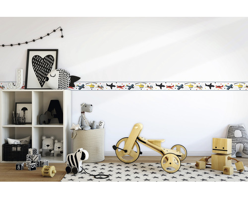Kinderzimmer mit Flugzeugbordüre an der Wand, Regal und Spielzeugdekoration.