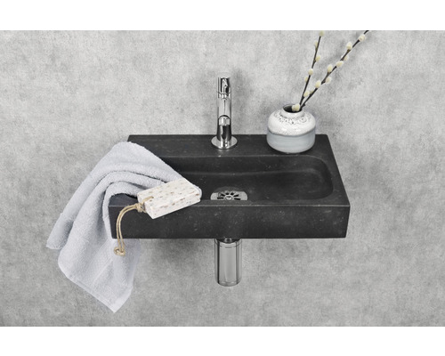 Waschbecken aus Stein mit Armatur, Handtuch und Seife