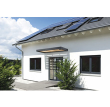 Hausfassade mit Fenstern, Haustür und Solarzellen auf dem Dach