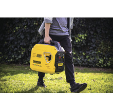 Eine Person trägt einen gelben Champion 2200 Watt Inverter Generator im Freien.