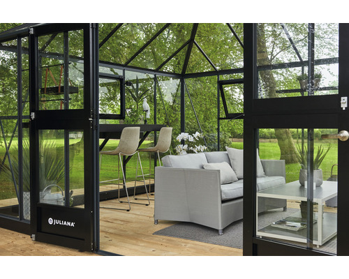 Innenansicht eines Gewächshauses mit Sitzmöbeln und Bar