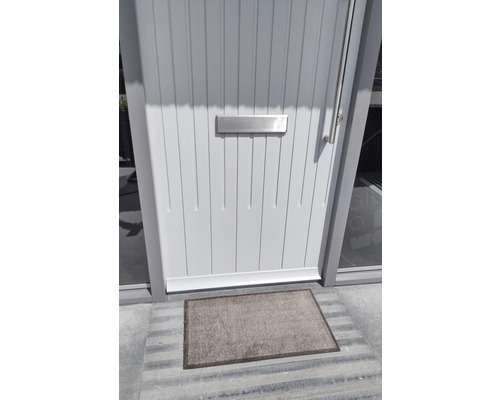 Helle Haustür mit Briefkasten und Fußmatte