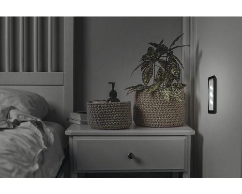 Schlafzimmer mit Bett, Nachttisch, Dekoration und Wandleuchte
