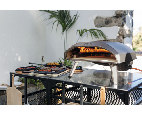 Ooni Gas Pizzaofen auf einem Tisch mit Speisen im Freien