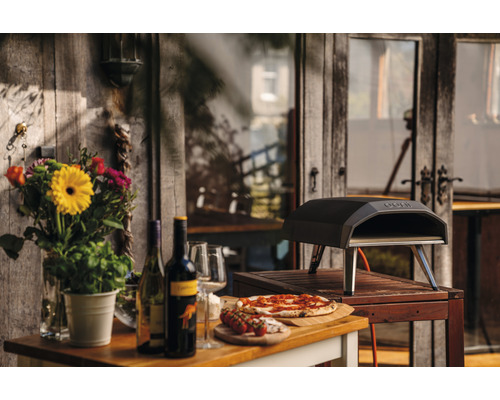 Außenbereichsszene mit Pizzaofen, Pizza, Wein und Blumen
