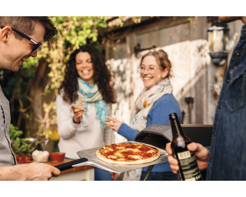 Personen feiern mit Pizzaofen im Freien