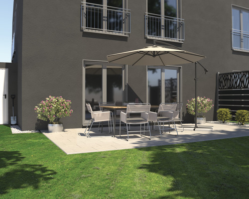 Außenbereich mit Terrassenmöbeln unter einem Sonnenschirm vor einem Wohnhaus