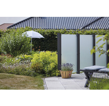 Gartenszene mit Sichtschutzzaun, Bepflanzung und Sonnenschirm