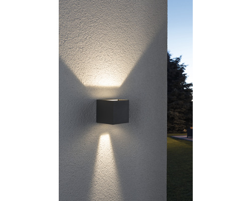 Quadratische Außenwandleuchte an einer Wand mit Lichtstrahlen nach oben und unten