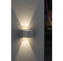 Kubische Wandleuchte für den Außenbereich mit Lichtstrahlen nach oben und unten.