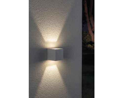 Kubische Wandleuchte für den Außenbereich mit Lichtstrahlen nach oben und unten.