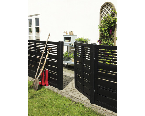 Gartenszene mit Holzzaun, Schaufel und Gummistiefeln