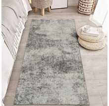 Grauer Teppich mit abstraktem Muster in einem Schlafzimmer.