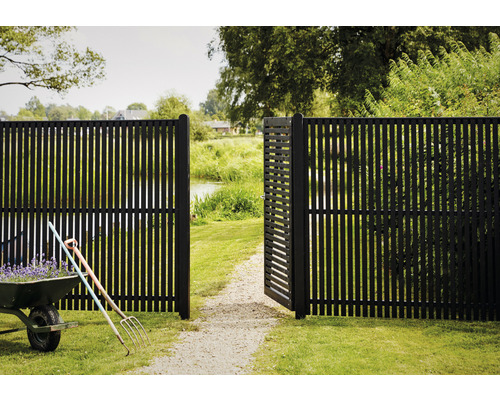 Gartenszene mit geöffnetem, senkrechtem Lattenzaun und Schubkarre