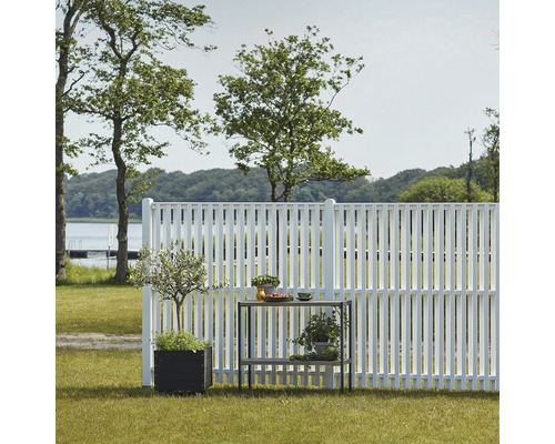 Szene mit weißem Gartenzaun, Pflanzen in Töpfen und einem Gartentisch