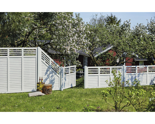 Gartenansicht mit Holzzaun und geöffnetem Gartentor vor einem Haus.