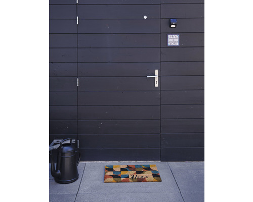 Eingangsbereich mit Fußmatte, Gießkanne und Haustür