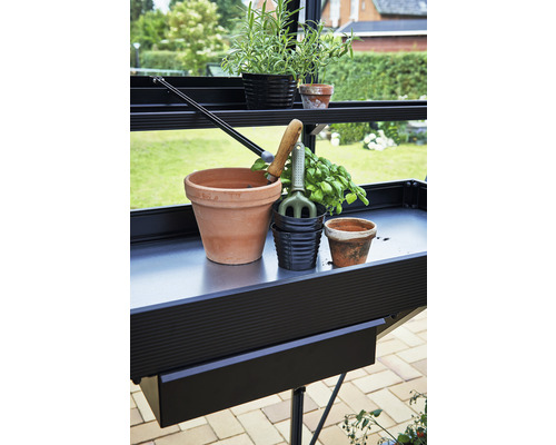Gartentisch mit Blumentöpfen und Gartengeräten