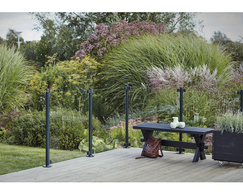 Terrassenszene mit Glasgeländer, Bank und Bepflanzung im Garten