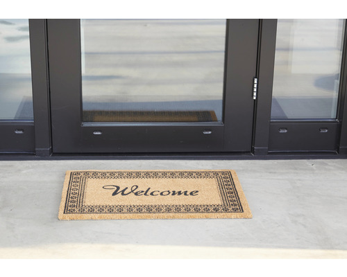 Fußmatte mit der Aufschrift Willkommen vor einer Tür