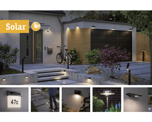 Außenbereich mit Solarleuchten an Hauswand, Garage und Weg