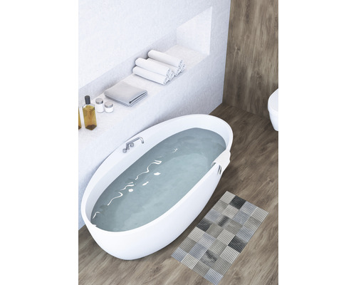 Badezimmer mit freistehender Badewanne, Handtüchern und Badteppich