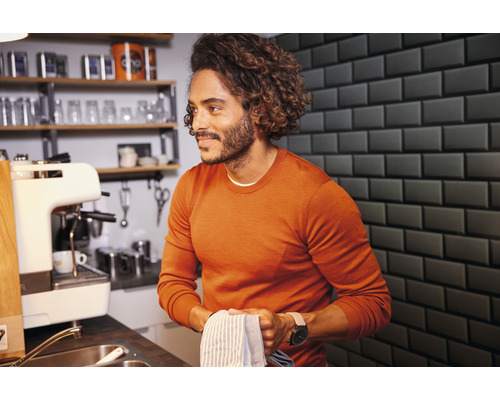 Mann in Küche mit Spüle, Kaffeemaschine und Geschirrregal