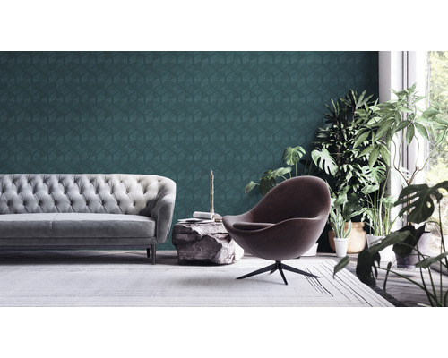 Wohnzimmer mit grauer Couch, Sessel und geometrischer Tapete