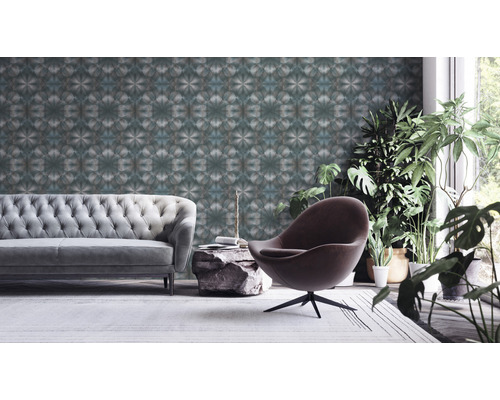 Wohnzimmer mit Sofa, Sessel, Zimmerpflanzen und gemusterter Tapete
